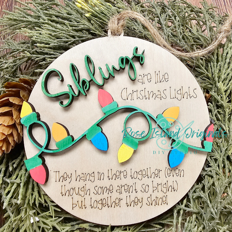 Wooden ornament with Christmas lights design and text on a green leaf background