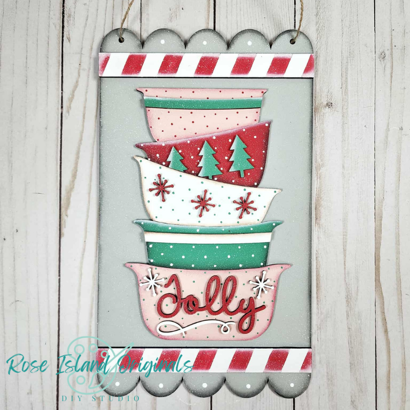Decorative sign with stacked bowls and 'Jolly' text on a wooden background