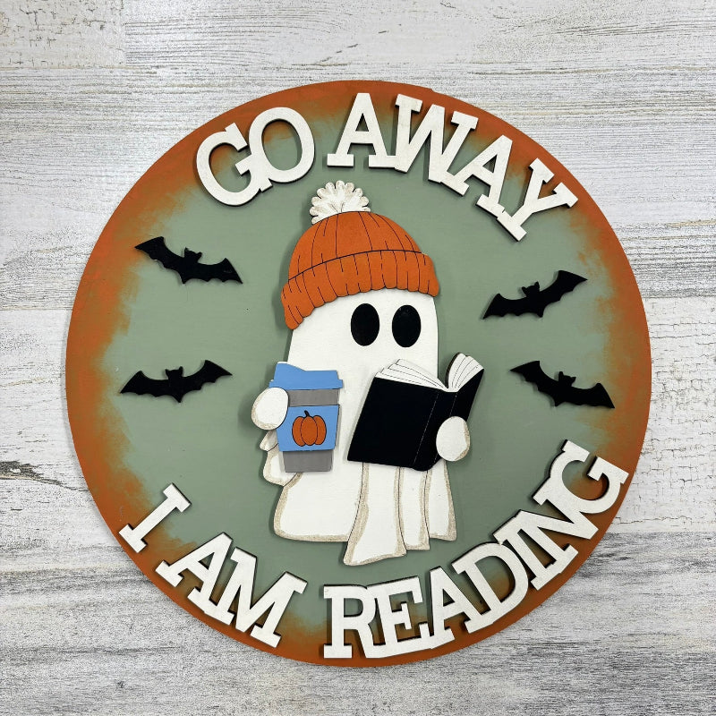 Ghost with a beanie and coffee reading a book on a green background.