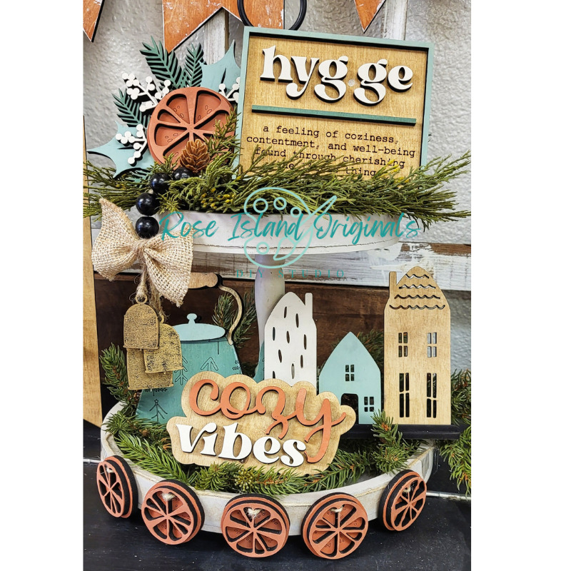 Decorative sign with 'hygge' and 'cozy vibes' text, surrounded by festive elements.