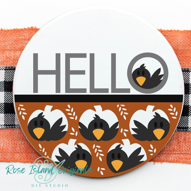 Round sign with word hello has crows looking out pumpkin cutouts on a white background