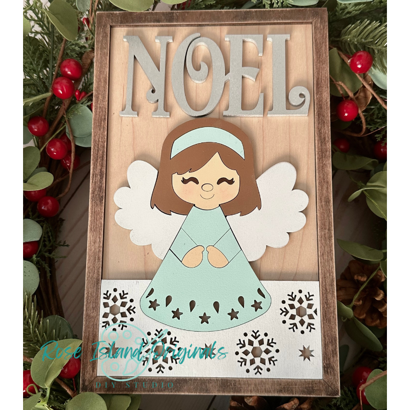 Decorative sign with angel and 'NOEL' text, surrounded by greenery and berries.