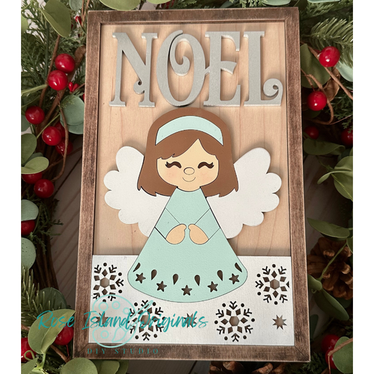 Decorative sign with angel and 'NOEL' text, surrounded by greenery and berries.