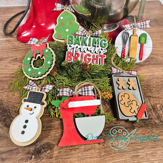 Decorative Christmas ornaments on a wooden surface with 'Baking spirits Bright' sign.