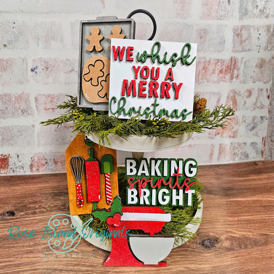 Decorative sign with Christmas-themed text and baking elements on a wooden surface.