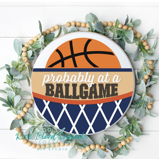 Decorative plate with basketball design and text 'Probably at a ballgame' surrounded by greenery on a white background.