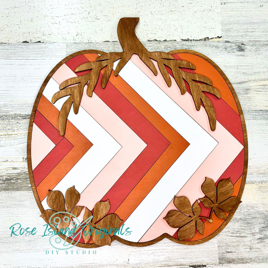 Decorative pumpkin with chevron quilt pattern and wooden leaves.