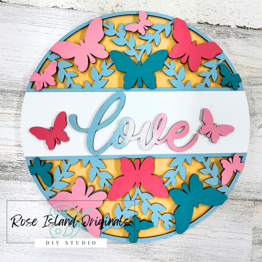 Decorative wall art with colorful butterflies and the word 'love' on a wooden background.