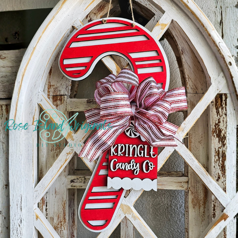Decorative candy cane sign with a bow on a wooden background