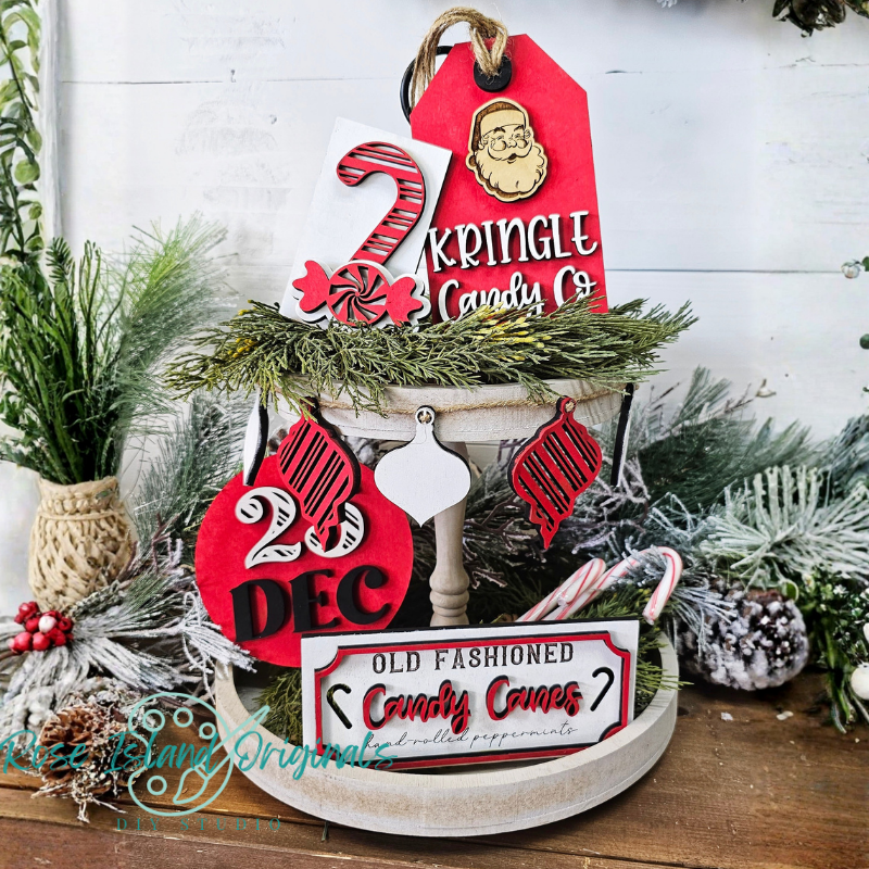 Decorative Christmas sign with Santa Claus and candy cane elements on a wooden surface.