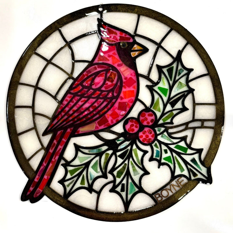 Stained glass window hanging with a cardinal and holly design on a white background.