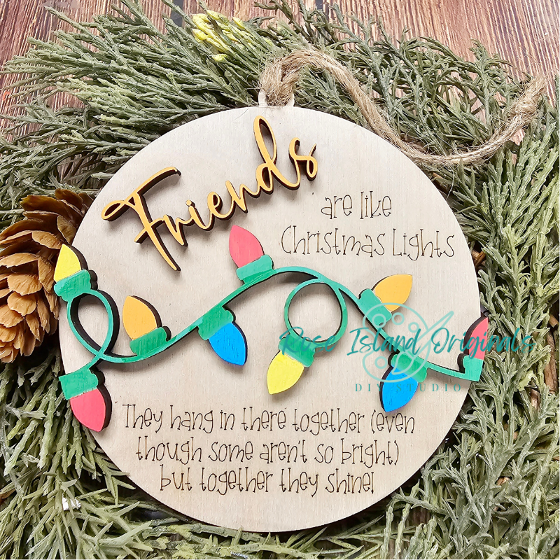 Decorative ornament with Christmas lights and text on a green leaf background