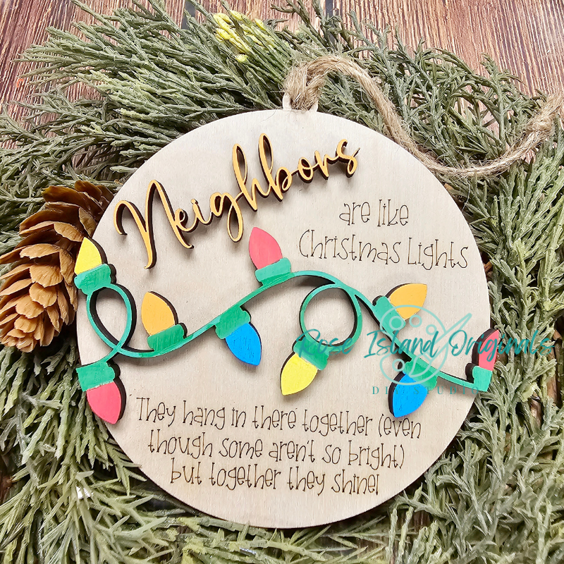 Decorative wooden ornament with Christmas lights and text on a green wreath.