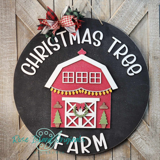 Decorative sign with a red barn and Christmas tree design on a wooden background
