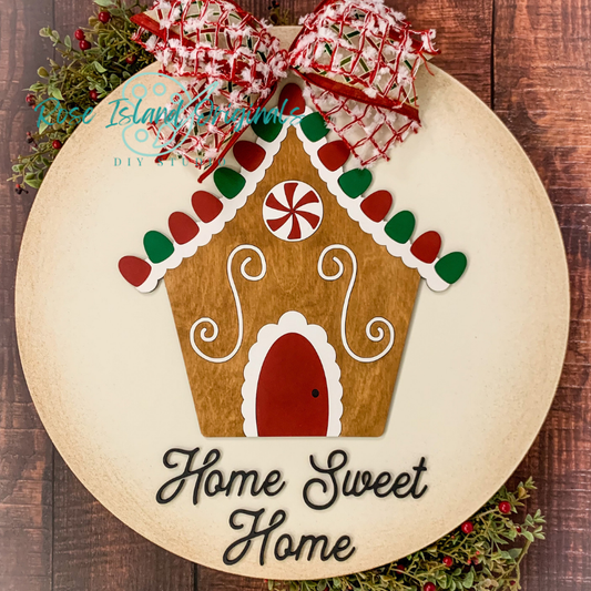 Decorative gingerbread house sign with 'Home Sweet Home' text on a wooden background.