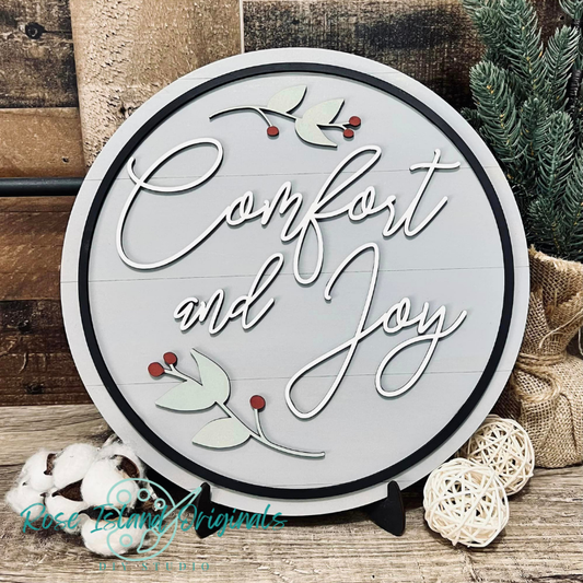 Round decorative sign with 'Comfort and Joy' text on a wooden background