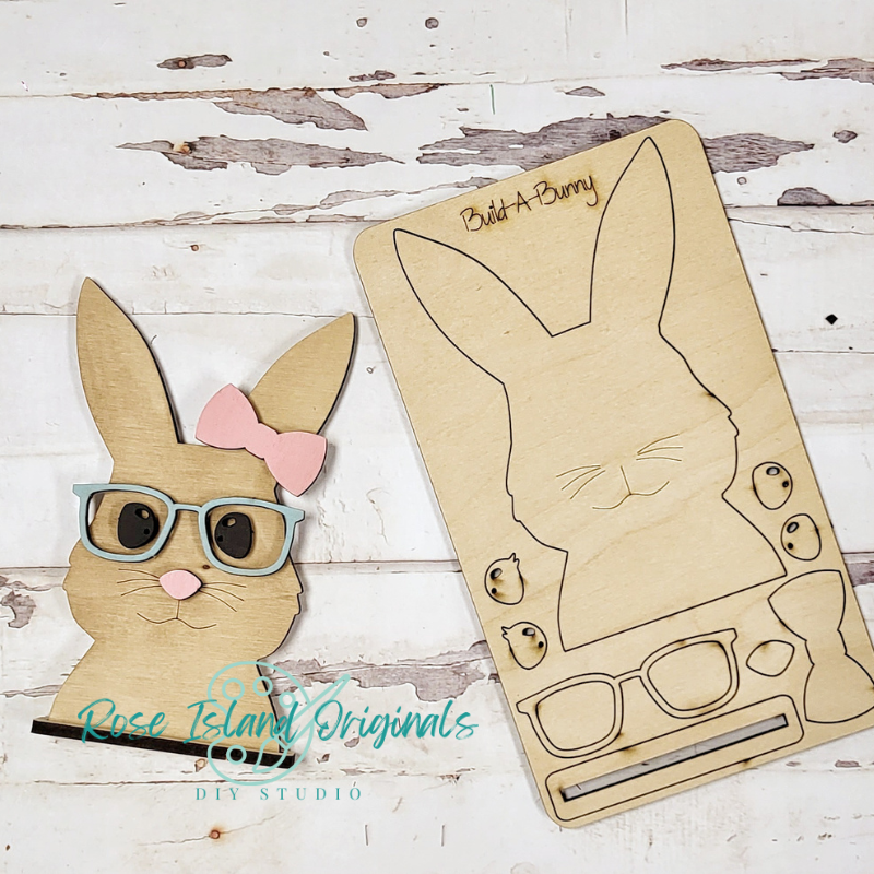 Wooden bunny cutout with glasses and bow, and a plain version on a wooden surface.