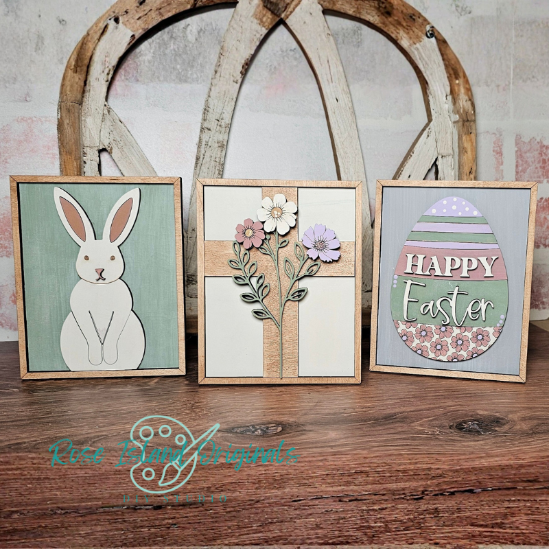 Three framed Easter-themed artworks on a wooden surface with a rustic background.