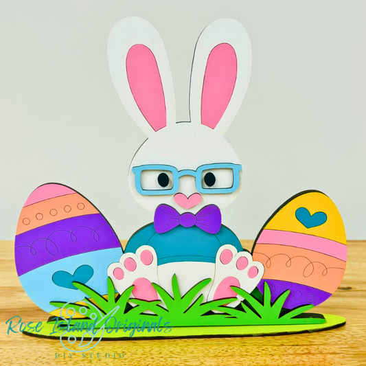 Colorful wood craft of a bunny with Easter eggs on a wooden surface