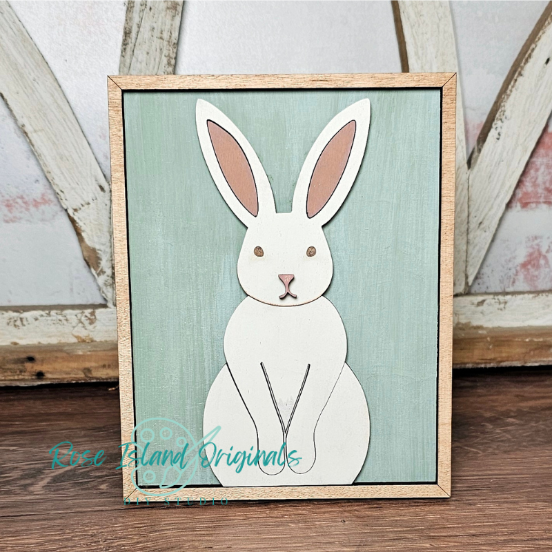 Framed illustration of a white rabbit on a teal background with 'Rose Island Originals' branding.