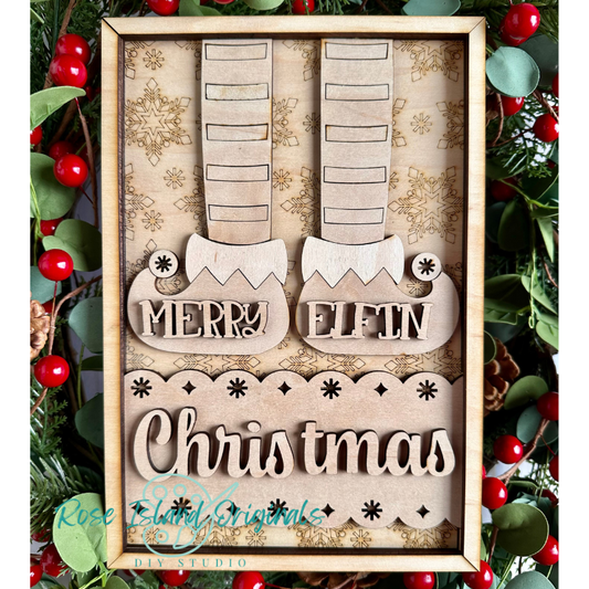 Wooden Christmas decoration with 'Merry Elfin Christmas' text, framed against a festive background.
