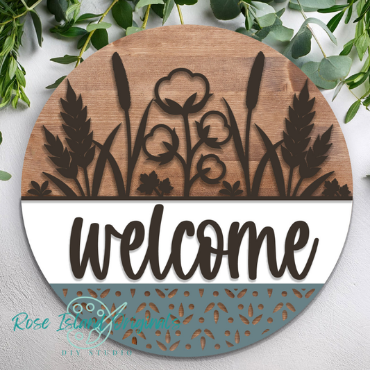 Round wooden sign with floral designs and the word 'welcome' on a light gray background.