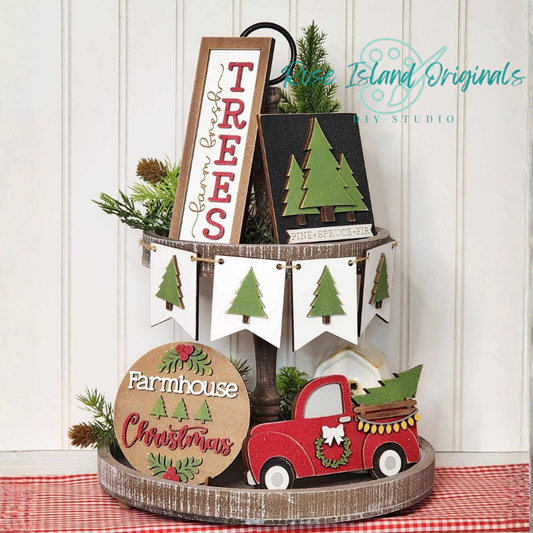 Decorative set with Christmas-themed signs and a red truck on a checkered tablecloth.