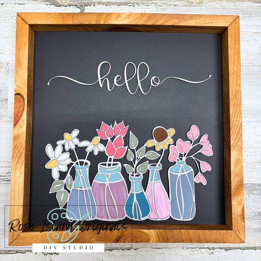 Decorative sign with flowers in vases and 'hello' text on a chalkboard background, framed in wood.