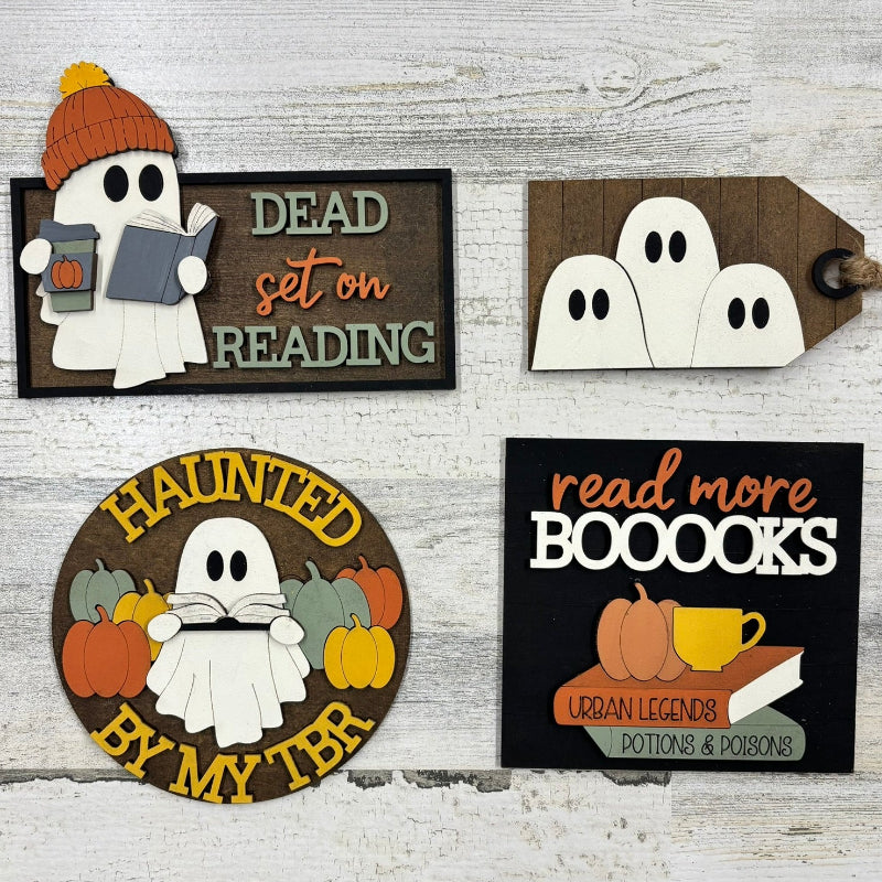 Set of Halloween-themed decorative signs with ghosts and autumn elements on a wooden background.