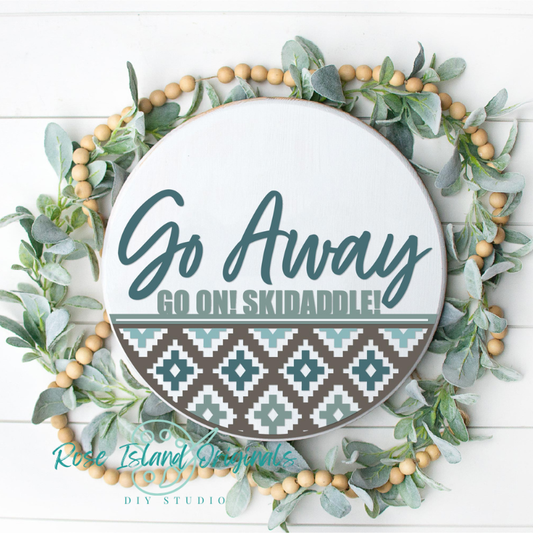 Decorative plate with 'Go Away Go On! Skidaddle!' text, surrounded by greenery and wooden beads on a white background.