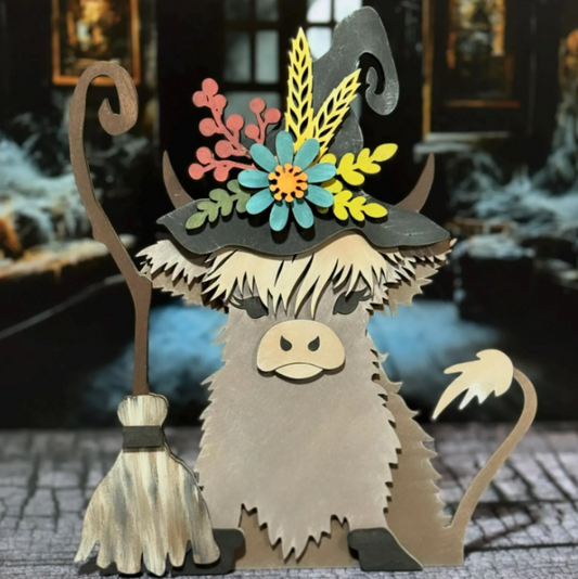 Highland cow with witch hat and broom with floral accents