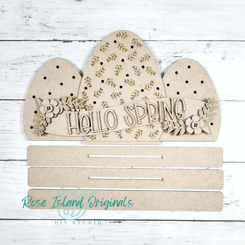 Wooden decorative sign with 'Hello Spring' text on a white wooden background, branded 'Rose Island Originals'.