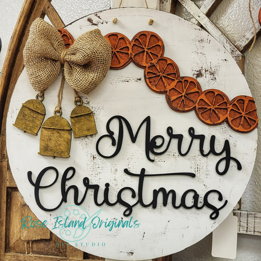 Wood round hanging sign with ells and orange slices featuring words merry Christmas.