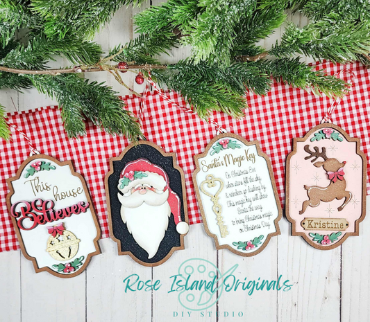 Decorative Christmas signs with Santa Claus, reindeer, and text on a wooden background with greenery and red checkered fabric.
