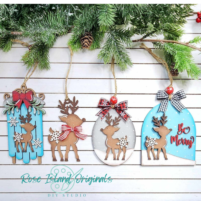 Set of Christmas-themed wooden reindeer decorations with ribbons and snowflakes on a white wooden background.