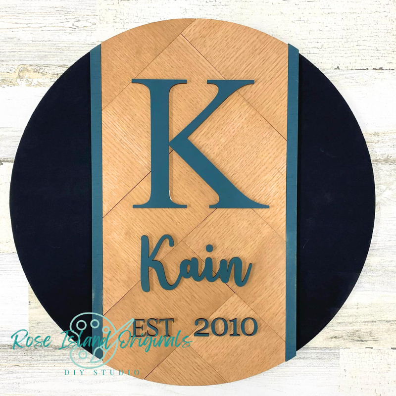 Wooden plaque with a large 'K' and the name 'Kain' along with 'EST. 2010' on a white background.