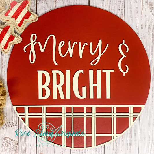 Round red sign with 'Merry & Bright' text on a wooden background