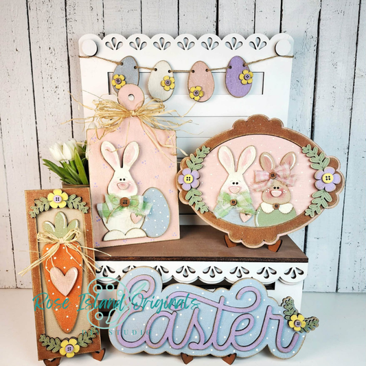 Decorative Easter signs with bunnies, eggs, and flowers on a wooden stand.