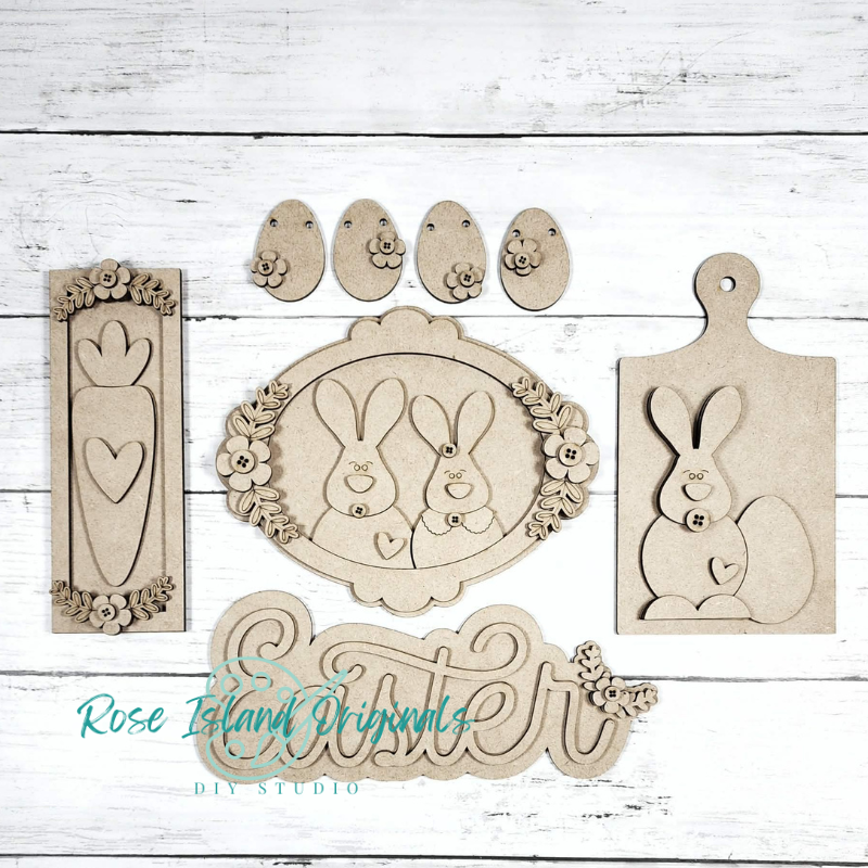Set of wooden craft pieces with Easter designs on a white wooden background.