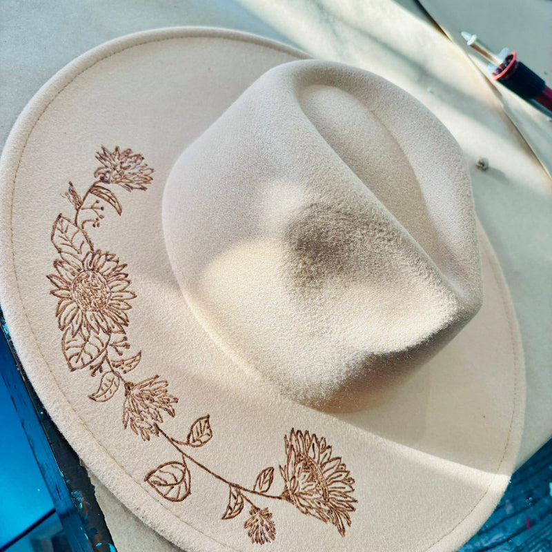 Ranch style hat in a cream color with wildflowers burned on the brim.
