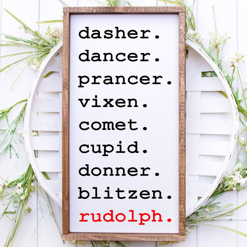 Framed list of reindeer names with 'rudolph' in red on a white wooden background.