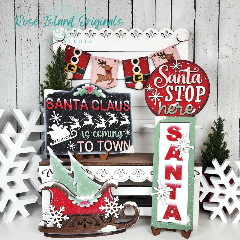 Set of Christmas-themed decorative signs with Santa Claus and winter elements on a wooden background.