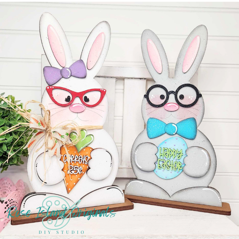 Two decorative Easter bunnies with glasses and bows on a white background.