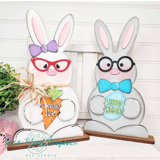 Two decorative Easter bunnies with glasses and bows on a white background.