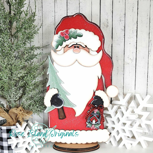 Wooden Santa Claus decoration with a Christmas tree and snowflakes on a wooden background.