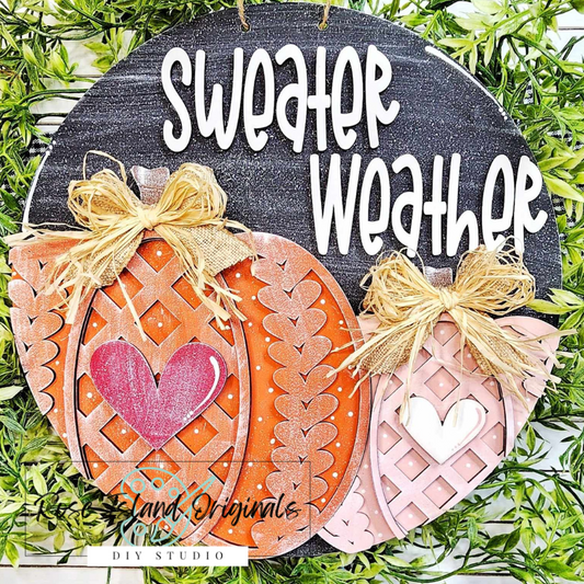 Decorative sign with sweater textured pumpkins and 'Sweater Weather' text on a black background