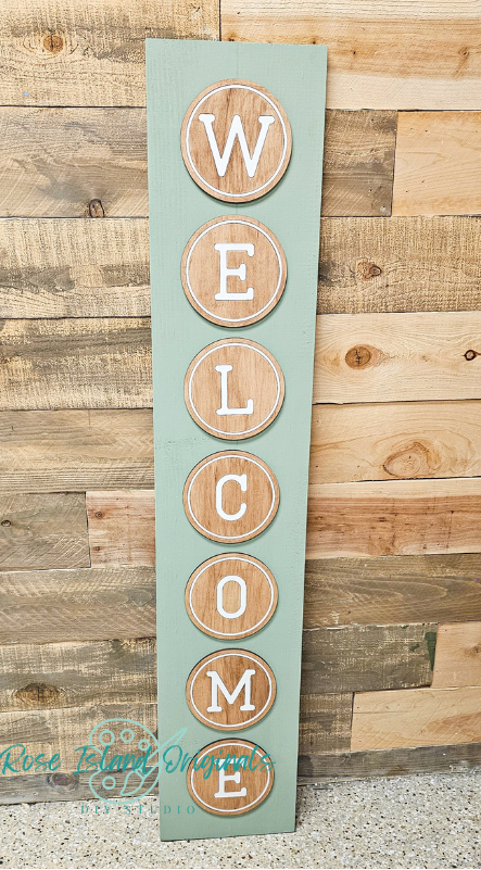 Wooden 'Welcome' sign with circular letters on a wooden background