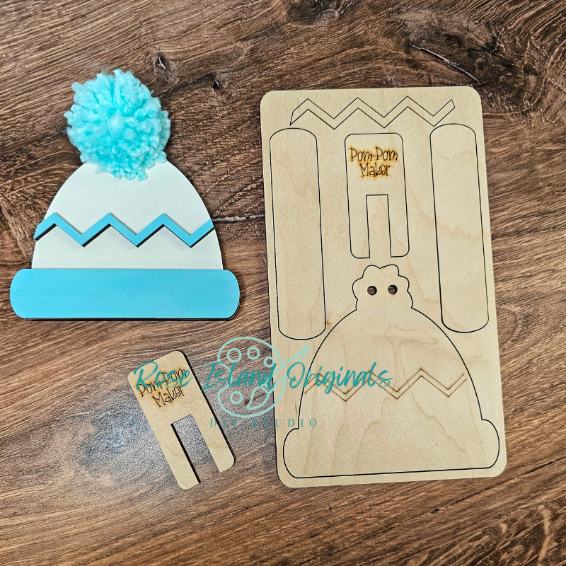 Wooden craft item shaped like a beanie with a pom-pom, a wooden template, and a small wooden tool on a wooden surface.