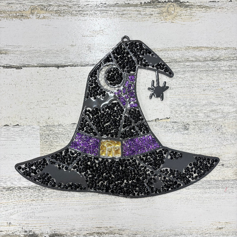 Decorative witch's hat with black and purple details on a wooden surface
