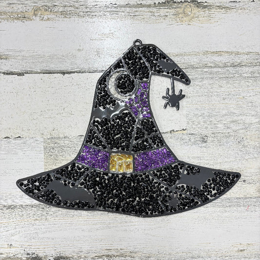 Decorative witch's hat with black and purple details on a wooden surface